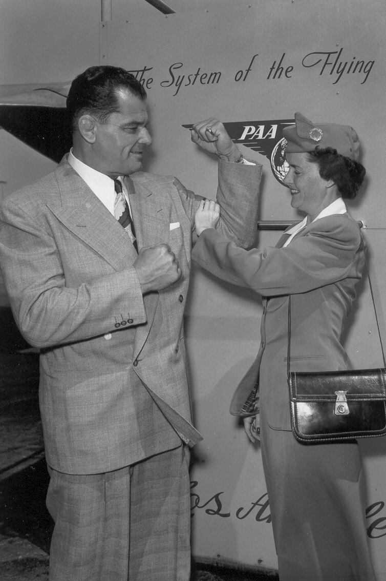 1950s Wrestler  Sandor Szabo shows off his strength to a Pan Am stewardess.